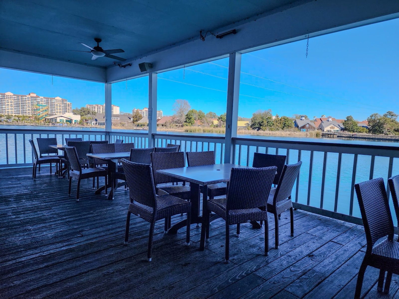 The covered deck on the lake, wicker chairs and blue sky